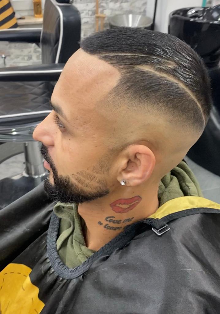 Klant van opzij met een strakke skin fade en een verzorgde baard